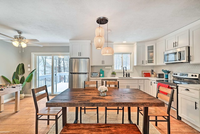 kitchen featuring a sink, light wood-style flooring, white cabinets, and stainless steel appliances