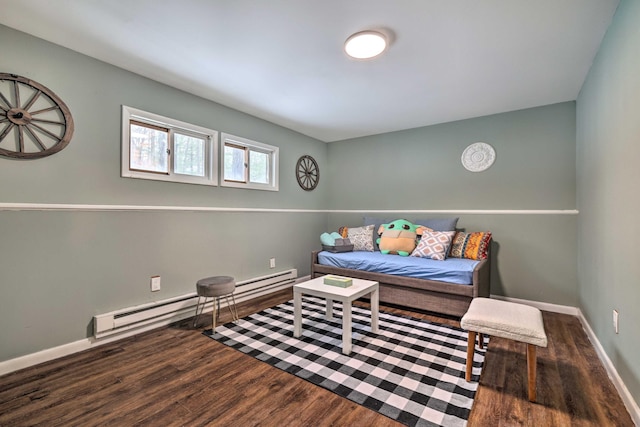 living area with a baseboard heating unit, baseboards, and wood finished floors