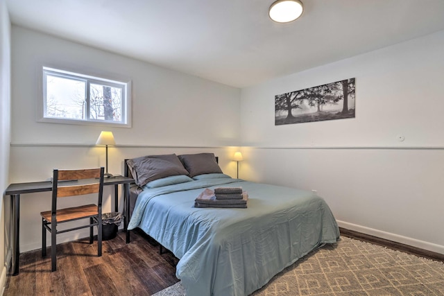 bedroom with baseboards and wood finished floors