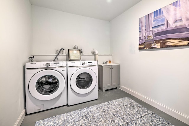 clothes washing area featuring a sink, baseboards, independent washer and dryer, and cabinet space