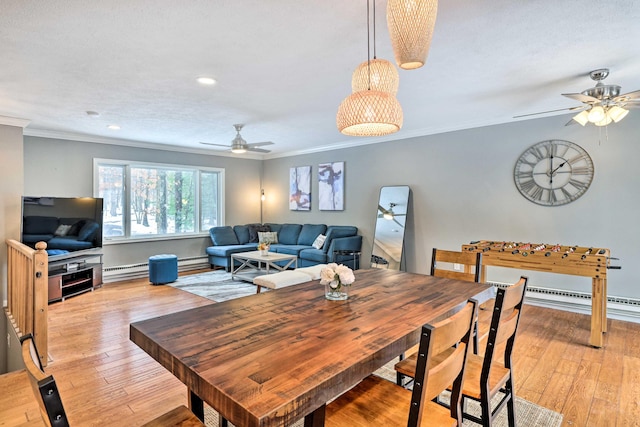 dining room featuring crown molding, baseboard heating, light wood finished floors, and a baseboard radiator