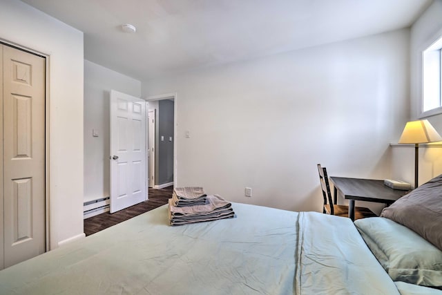 bedroom with baseboard heating and dark wood-style flooring