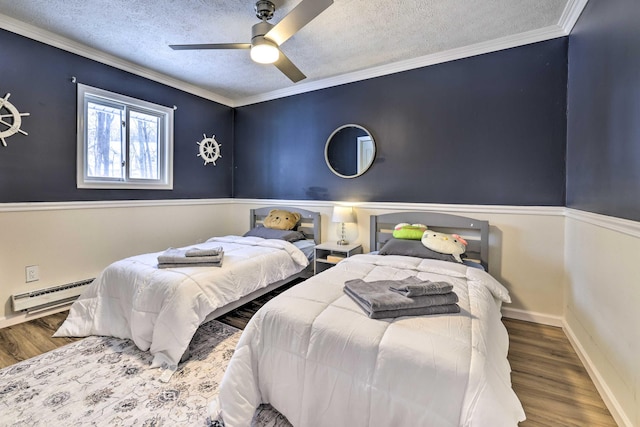 bedroom with ornamental molding, baseboard heating, wood finished floors, a textured ceiling, and a ceiling fan