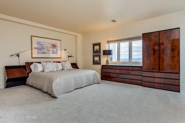 bedroom with visible vents and light colored carpet