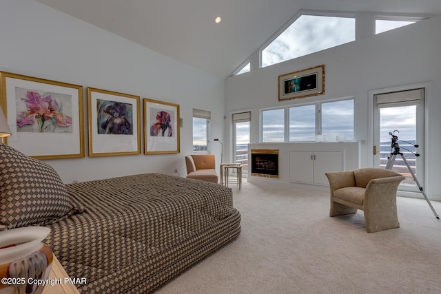 bedroom with light carpet, access to exterior, a fireplace, and high vaulted ceiling