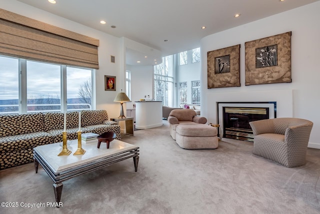 living room featuring recessed lighting, carpet flooring, and a glass covered fireplace