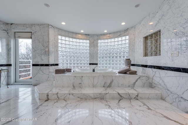 full bath with stone wall, recessed lighting, tile walls, marble finish floor, and a bath