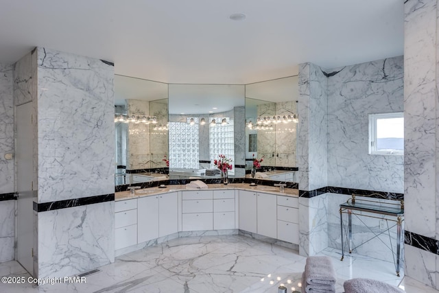 bathroom featuring stone wall, marble finish floor, and vanity