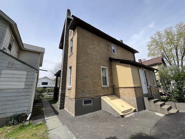 exterior space with a chimney and brick siding