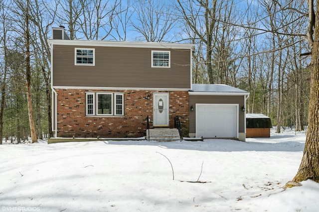 colonial house featuring a garage, brick siding, and a chimney