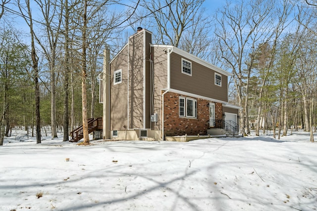 view of front of home featuring brick siding and a chimney