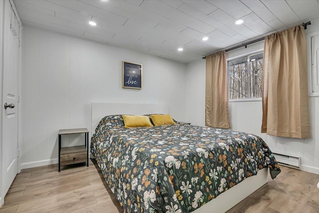 bedroom with recessed lighting, a baseboard heating unit, baseboards, and wood finished floors