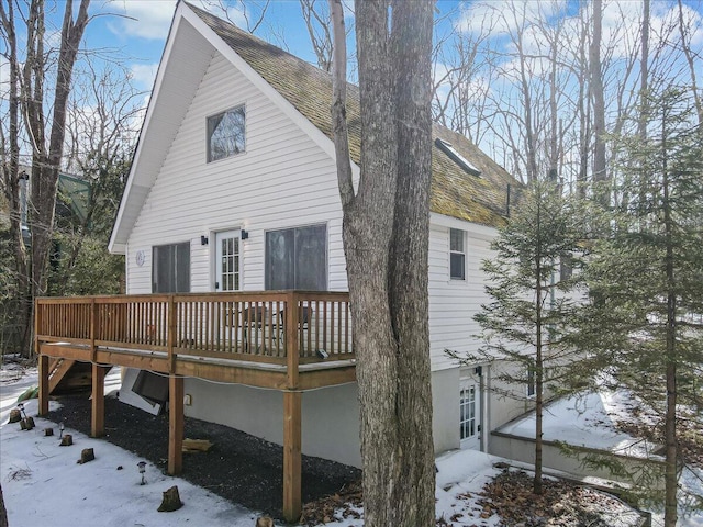 back of house with a deck and a shingled roof