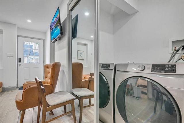 clothes washing area with recessed lighting, laundry area, washer and dryer, and light wood-type flooring