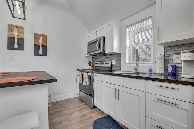 kitchen with dark countertops, stainless steel appliances, and a sink