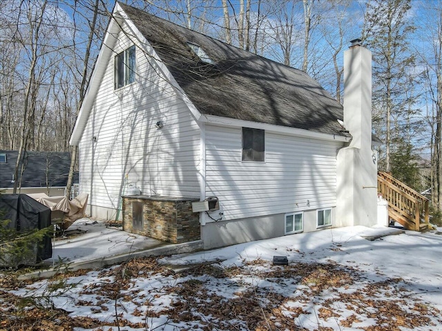 snow covered property with a chimney