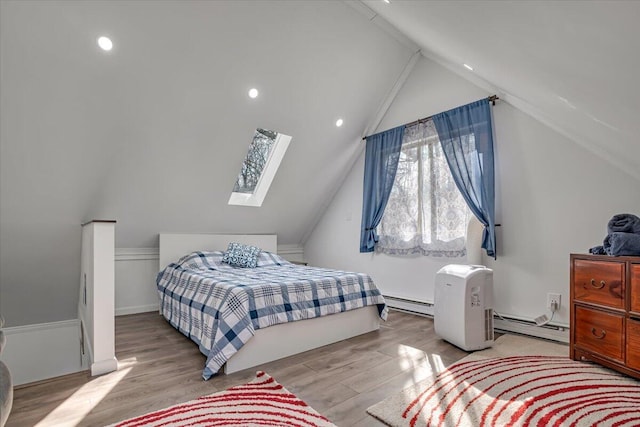 bedroom with vaulted ceiling with skylight, recessed lighting, wood finished floors, and baseboard heating