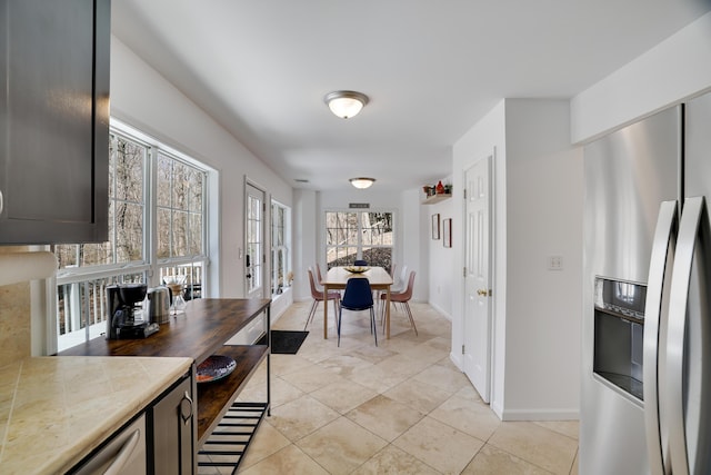 106 Alwen Ave, East Stroudsburg, PA 18301 - kitchen with stainless steel fridge, light tile patterned floors, tile countertops, and baseboards