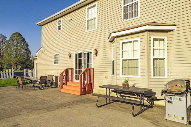 rear view of house featuring fence, a patio area, and outdoor dining area