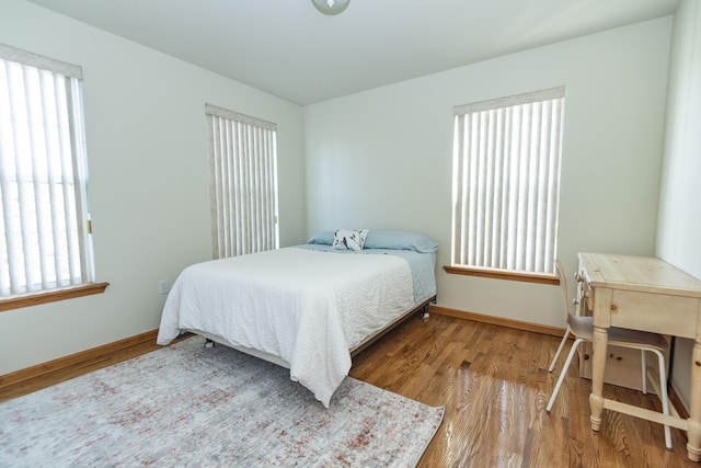 bedroom with wood finished floors and baseboards