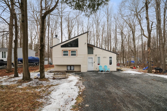 view of front of house with driveway and a chimney