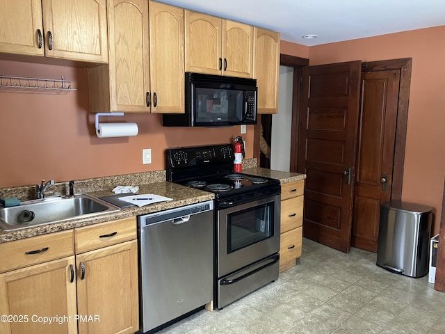 kitchen featuring light floors, light brown cabinets, stainless steel appliances, and a sink