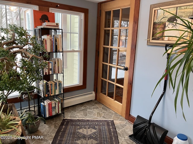 doorway to outside with baseboard heating and stone finish floor