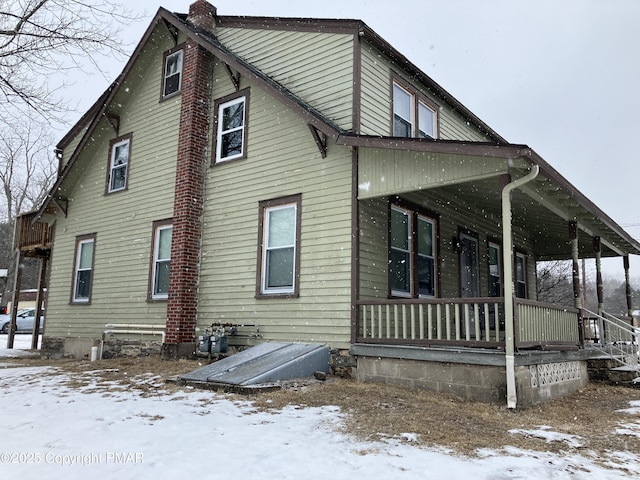 view of snowy exterior featuring covered porch