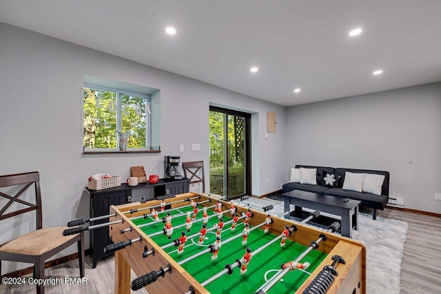 rec room with light wood-type flooring, a baseboard heating unit, baseboards, and recessed lighting