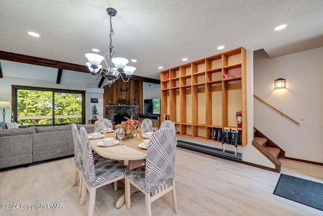 dining room featuring a textured ceiling, stairway, a fireplace, and wood finished floors