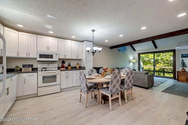 kitchen with white appliances, dark countertops, open floor plan, beamed ceiling, and light wood-type flooring