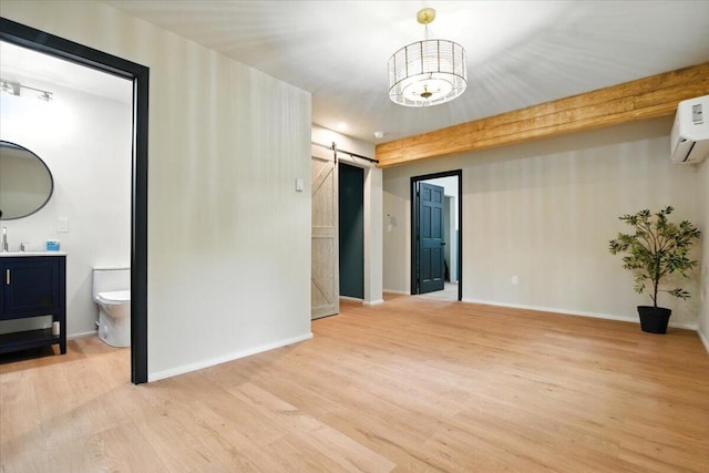 754 Clubhouse Dr, East Stroudsburg, PA 18302 - spare room with a barn door, light wood-style floors, a wall mounted AC, and a chandelier
