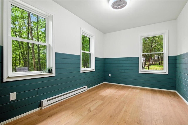 754 Clubhouse Dr, East Stroudsburg, PA 18302 - empty room featuring baseboard heating, plenty of natural light, a wainscoted wall, light wood-style flooring, and wooden walls