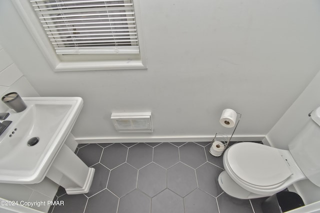 bathroom featuring visible vents, a sink, toilet, and tile patterned floors