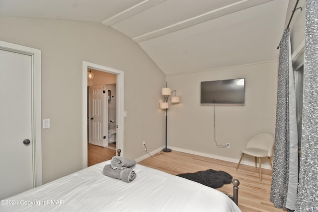 bedroom featuring lofted ceiling, baseboards, and wood finished floors