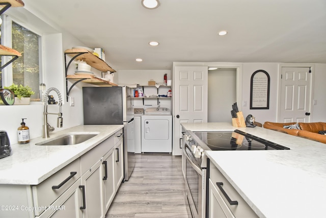 kitchen featuring washer and clothes dryer, appliances with stainless steel finishes, open shelves, a sink, and recessed lighting