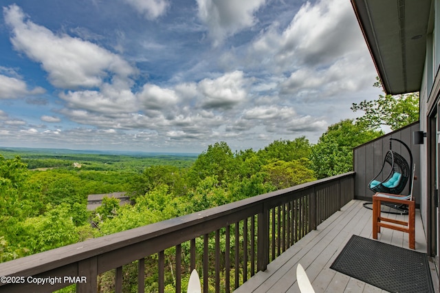 wooden terrace featuring a forest view