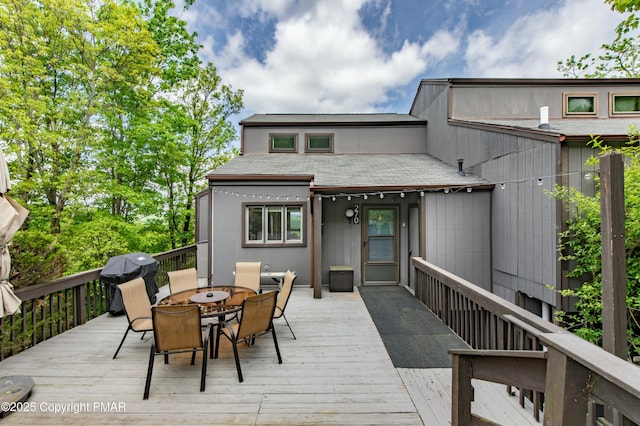 wooden deck with outdoor dining area and grilling area