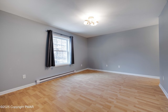 empty room featuring a baseboard radiator and light hardwood / wood-style flooring