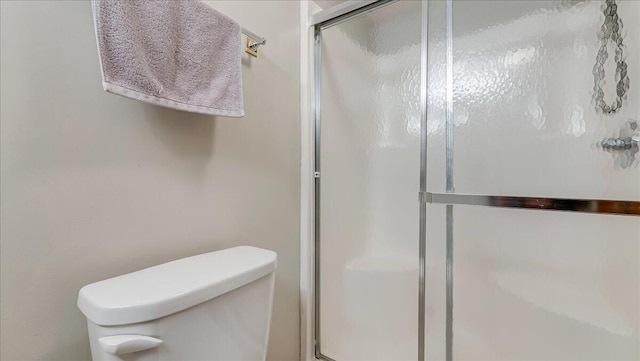 full bathroom with a shower stall and toilet