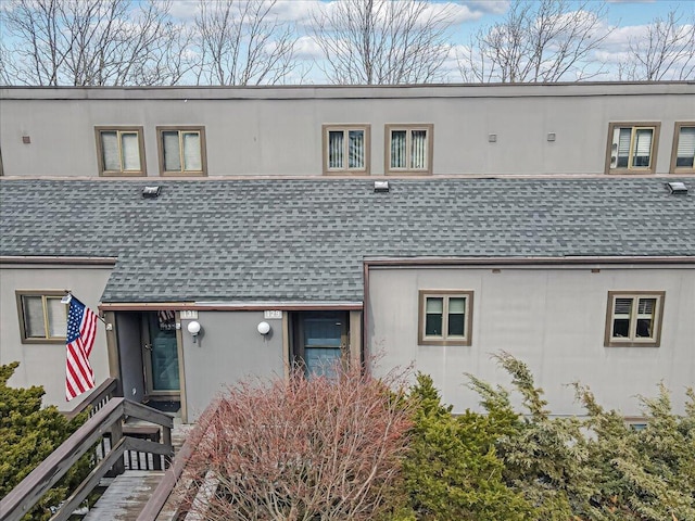 view of front of house with roof with shingles and stucco siding