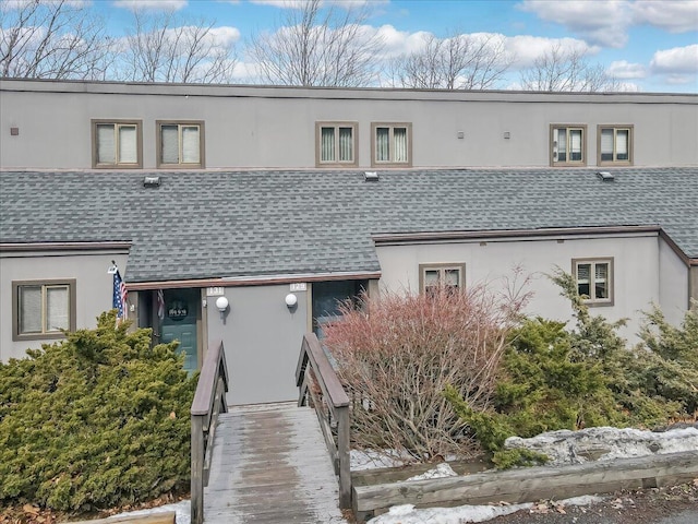 multi unit property featuring roof with shingles and stucco siding