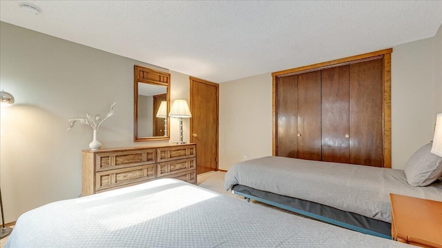 bedroom with a textured ceiling, a closet, and carpet