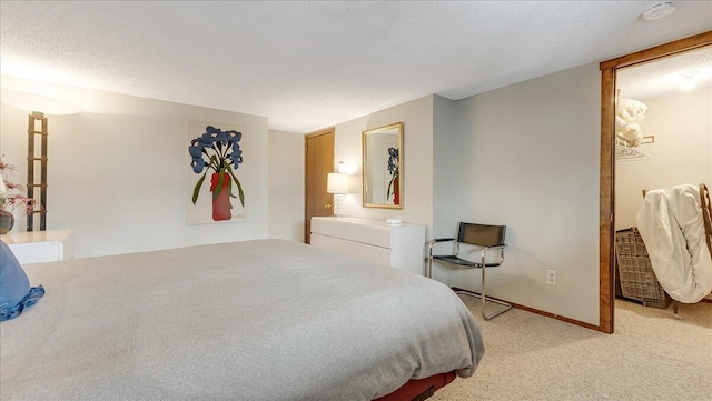 bedroom featuring light colored carpet, a textured ceiling, and baseboards