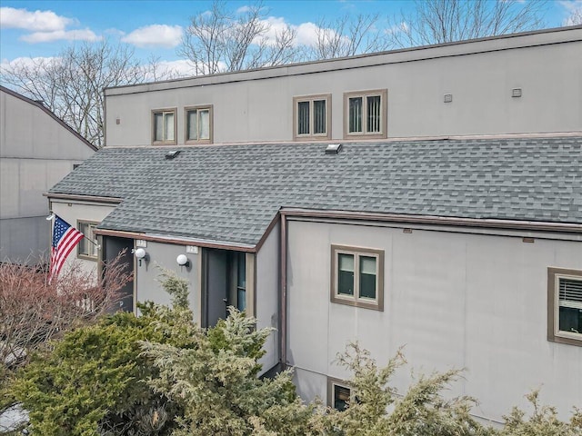 back of house with a shingled roof