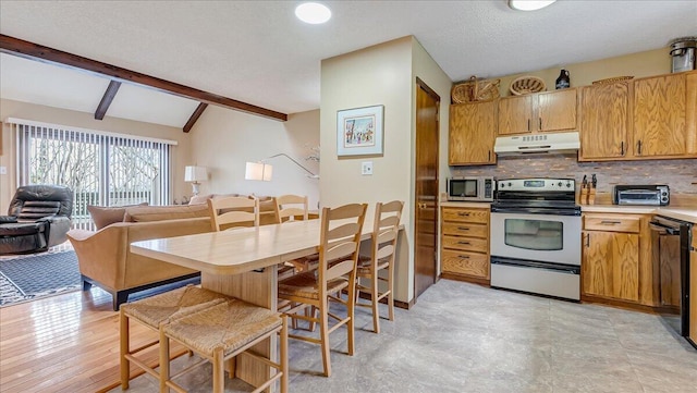 kitchen with under cabinet range hood, open floor plan, light countertops, appliances with stainless steel finishes, and decorative backsplash