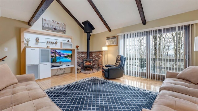 living room with a wood stove, lofted ceiling with beams, an AC wall unit, and wood finished floors