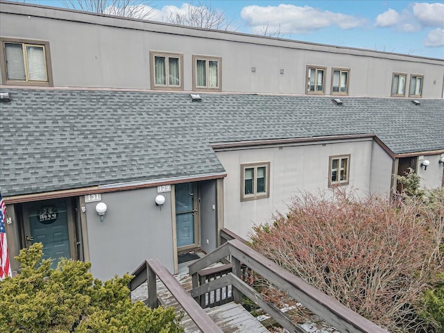 view of front of house featuring a shingled roof and stucco siding