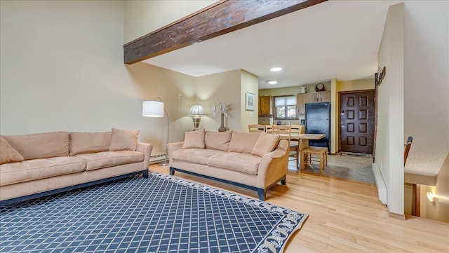 living room with beam ceiling, light wood finished floors, and baseboard heating