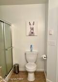 bathroom featuring baseboards, a shower stall, and toilet